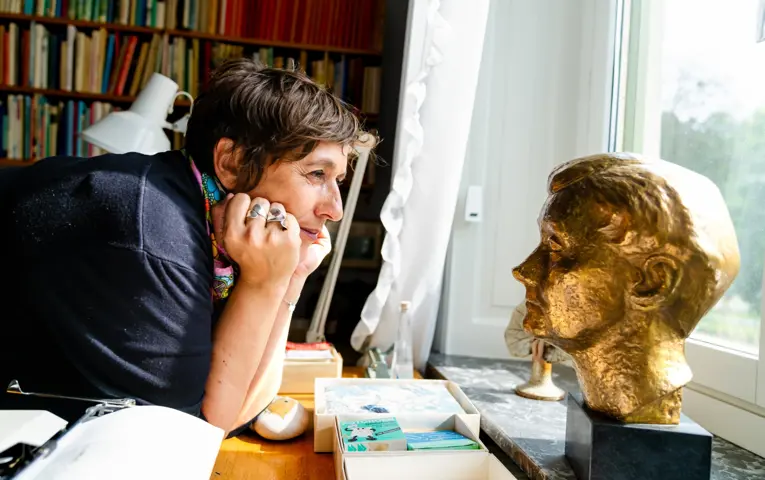 Marion Brunet looking at a golden statue of Astrid Lindgren