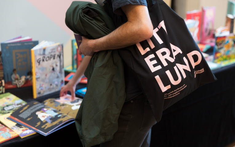 En person med en tygkasse där det står "Litteralund"
