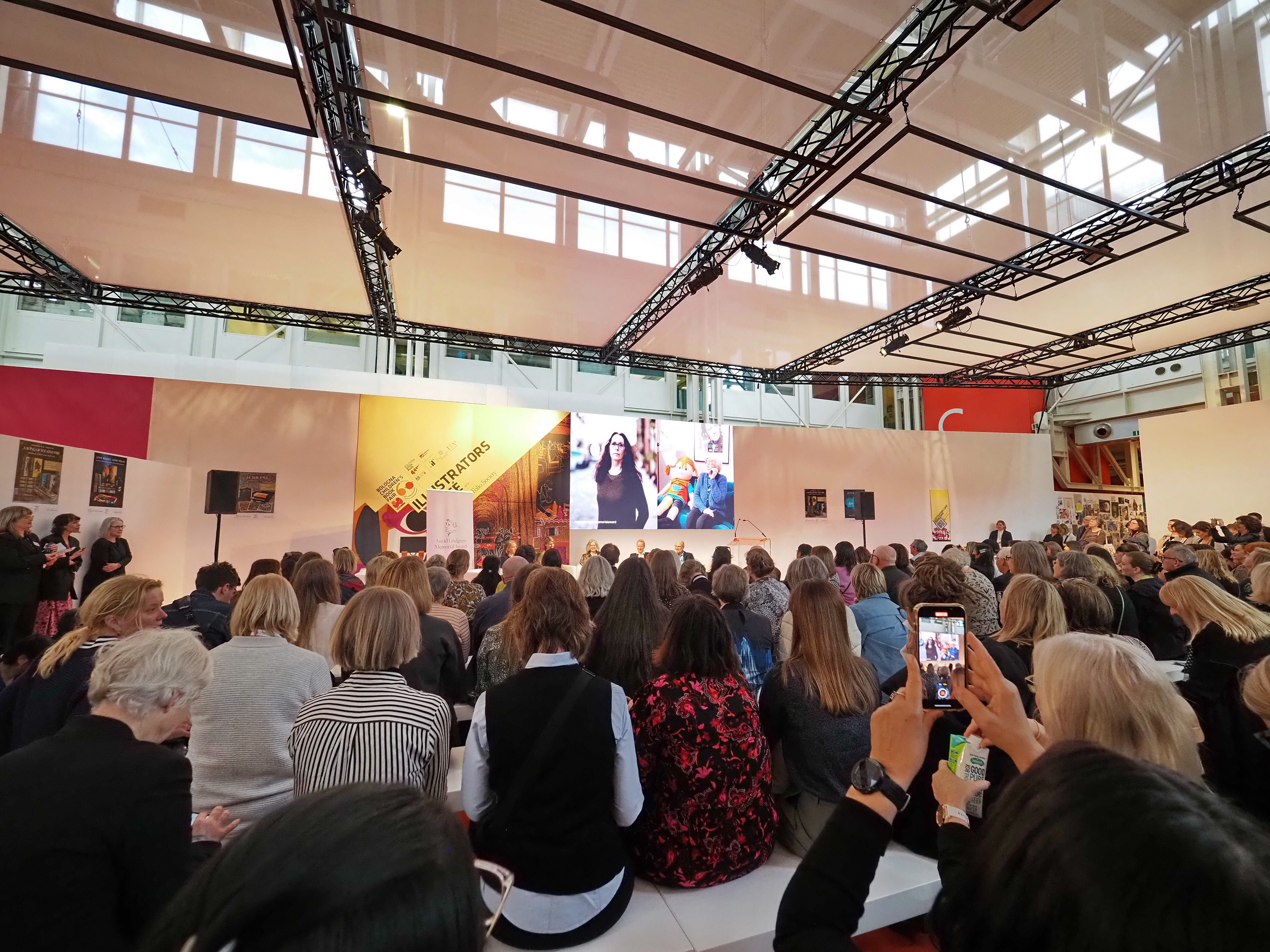 Audience in Bologna watching the announcement