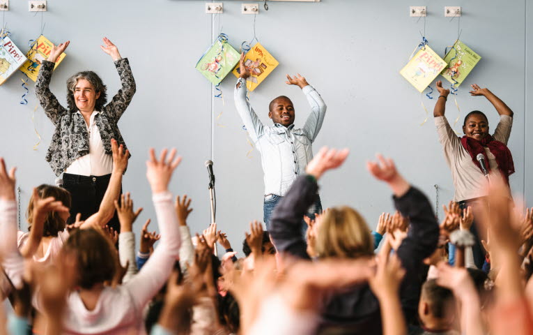 ALMA-pristagare från Sydafrika med händerna upp i luften framför en publik.