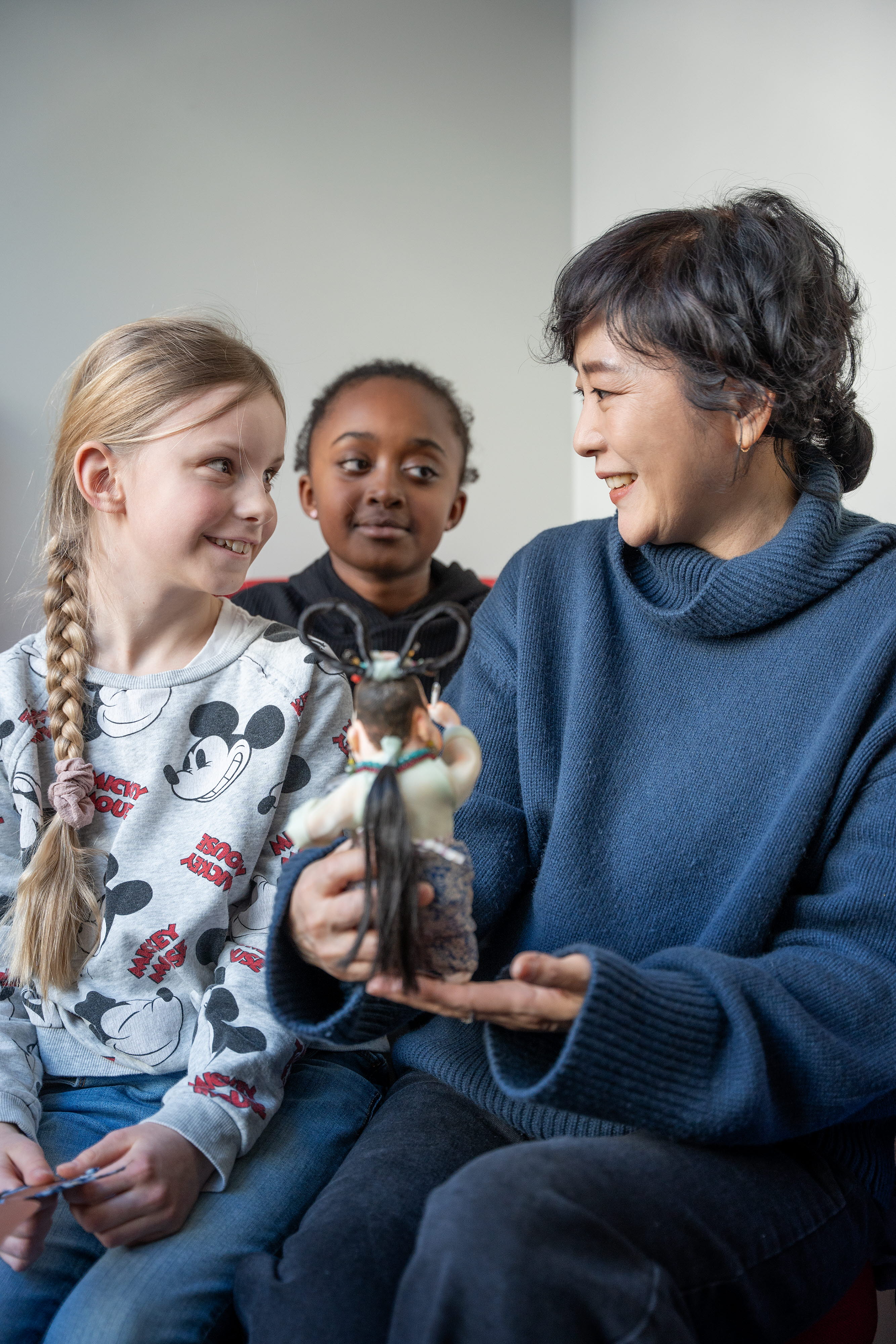 Baek Heena showing her figurine "Odd Mama" to two kids