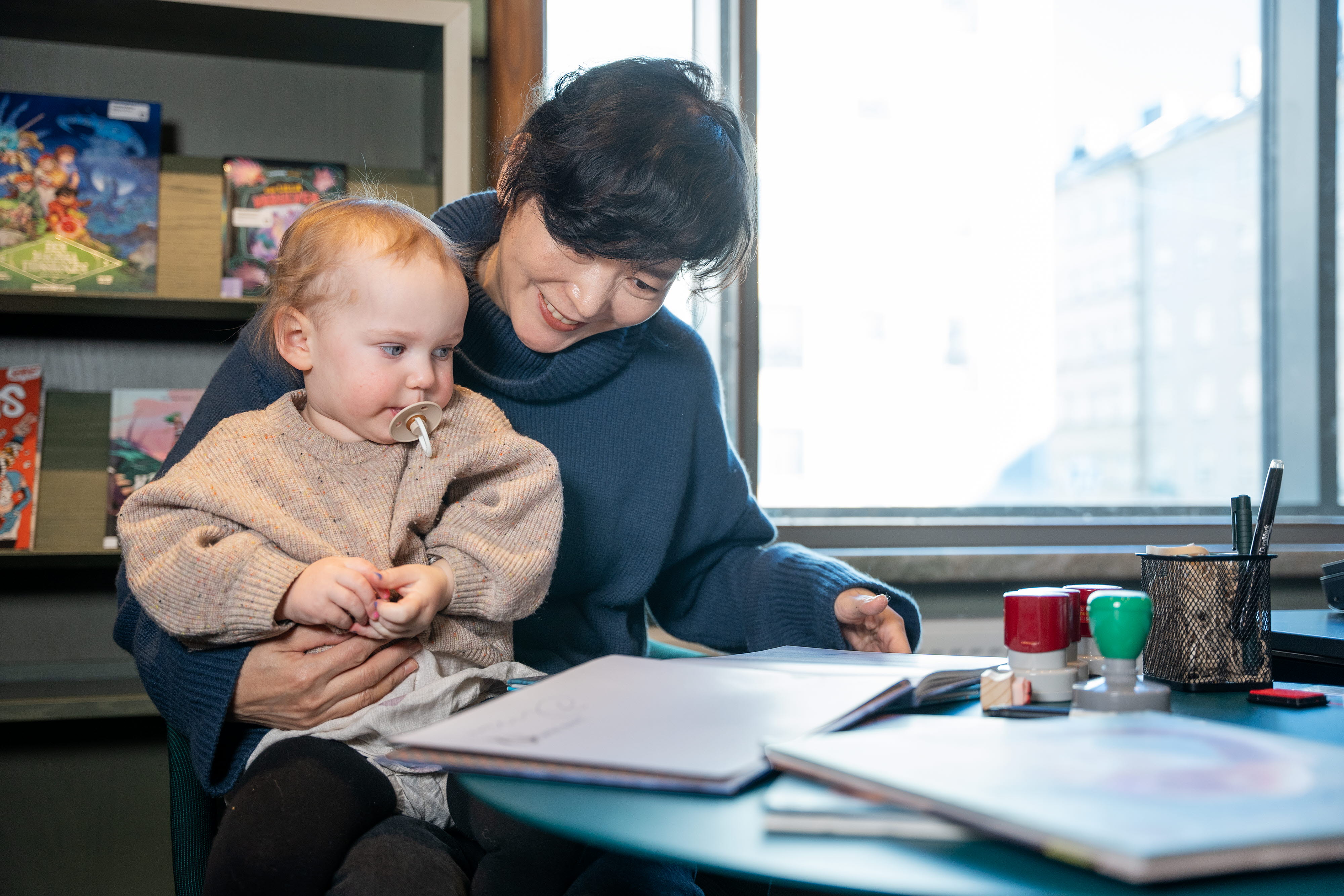 Baek Heena reading a book for a baby